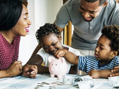 Parents-help-children-count-money-in-piggy-bank